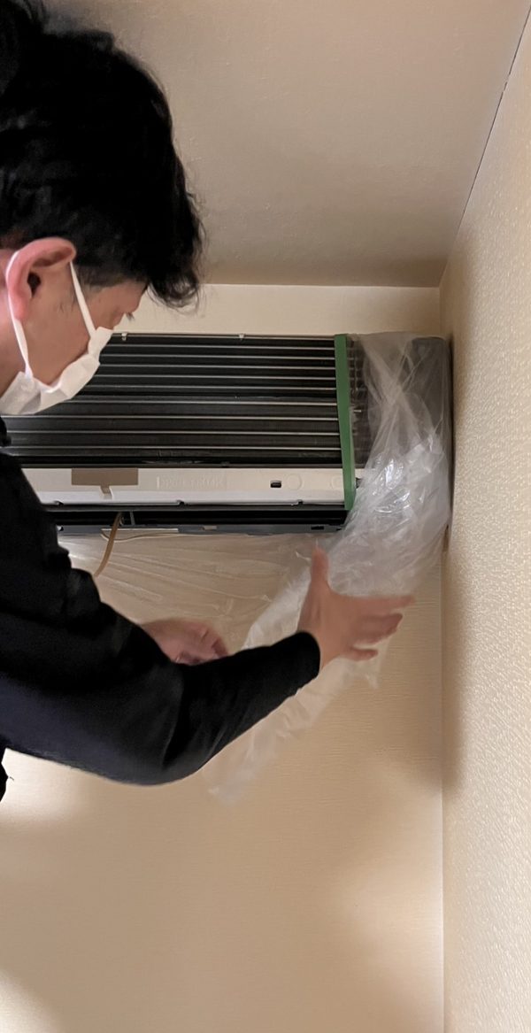 エアコンクリーニング前に新品のビニールで養生している様子